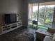 Inviting living room with a large TV, balcony access, and comfortable seating for relaxing or entertaining at 8101 Coconut Palm Way # 303, Kissimmee, FL 34747