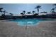 Community swimming pool with gazebo, lounge chairs, umbrellas, and brick paver deck, perfect for relaxation at 8101 Coconut Palm Way # 303, Kissimmee, FL 34747