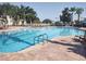 A pristine community pool surrounded by comfortable lounge chairs, lush greenery, and shade umbrellas at 8101 Coconut Palm Way # 303, Kissimmee, FL 34747