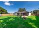 Expansive backyard offering green grass, a brick patio, well-maintained landscaping, and privacy fencing at 812 Adour Dr, Kissimmee, FL 34759