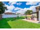 Beautiful backyard featuring lush green grass, a brick patio, white fence, and various plants and flowers at 812 Adour Dr, Kissimmee, FL 34759