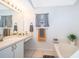 Bright bathroom featuring a tub, vanity with dual sinks, and large mirror at 812 Adour Dr, Kissimmee, FL 34759