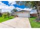 Exterior view of a home featuring a two-car garage and a long concrete driveway at 812 Adour Dr, Kissimmee, FL 34759