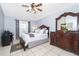 Cozy bedroom featuring a ceiling fan, dresser, and bedside desk at 812 Adour Dr, Kissimmee, FL 34759