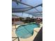 Private backyard pool with a screened enclosure and lounging area at 939 Jaybee Ave, Davenport, FL 33897