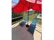 Relaxing screened-in poolside area with blue lounge chairs and a red umbrella at 939 Jaybee Ave, Davenport, FL 33897