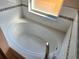 Jetted bathtub in an alcove next to a small window at 1006 Soaring Eagle Ln, Kissimmee, FL 34746