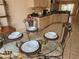Close-up view of an elegant glass dining table, with a view of the kitchen, making it great for casual dining at 1006 Soaring Eagle Ln, Kissimmee, FL 34746