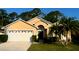 Charming single-story home with a two-car garage, palm trees, and well-manicured lawn at 1006 Soaring Eagle Ln, Kissimmee, FL 34746
