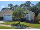 Inviting single-story home with a manicured lawn, palm tree, and attached two-car garage at 1006 Soaring Eagle Ln, Kissimmee, FL 34746