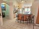 Open kitchen with a breakfast bar, neutral cabinetry, modern appliances, and tiled floors, great for entertaining at 1006 Soaring Eagle Ln, Kissimmee, FL 34746