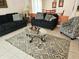 Comfortable living room with tile floors, sofas, stylish rug, and access to the dining area at 1006 Soaring Eagle Ln, Kissimmee, FL 34746
