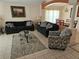 Inviting living room with tile flooring, two sofas, area rug, and view to the dining area at 1006 Soaring Eagle Ln, Kissimmee, FL 34746