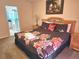 Bedroom showcasing a queen bed with floral comforter, matching lamps, and access to the bathroom at 1006 Soaring Eagle Ln, Kissimmee, FL 34746