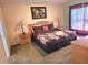 Comfortable primary bedroom with carpet, a floral comforter, and wooden furniture at 1006 Soaring Eagle Ln, Kissimmee, FL 34746