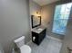 Bathroom featuring decorative floors, updated vanity with granite countertop, and modern lighting at 1020 Siena Park W Blvd # 304, Kissimmee, FL 34747