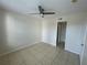 Neutral bedroom with a ceiling fan and tile floors. Two doorways visible at 1020 Siena Park W Blvd # 304, Kissimmee, FL 34747