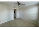Neutral bedroom with a ceiling fan and tile floors. Doorways to other rooms visible at 1020 Siena Park W Blvd # 304, Kissimmee, FL 34747