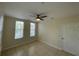 Cozy bedroom featuring tile flooring, ceiling fan, and natural light from large windows at 1020 Siena Park W Blvd # 304, Kissimmee, FL 34747