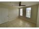 Comfortable bedroom with tile flooring, a ceiling fan, and two windows offering outdoor views at 1020 Siena Park W Blvd # 304, Kissimmee, FL 34747