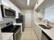 Well-equipped kitchen with stainless steel appliances, white cabinets, and neutral countertop and tile flooring at 1020 Siena Park W Blvd # 304, Kissimmee, FL 34747