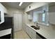 Modern kitchen featuring stainless steel appliances, white cabinets, and open view into living area at 1020 Siena Park W Blvd # 304, Kissimmee, FL 34747