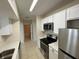 Modern kitchen with stainless steel appliances and views to hallway and bathroom at 1020 Siena Park W Blvd # 304, Kissimmee, FL 34747