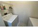 Bright laundry room equipped with a washing machine, dryer, and wire shelving for storage at 1020 Siena Park W Blvd # 304, Kissimmee, FL 34747