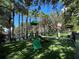 Community playground with green turf, slide, and surrounding mature palm trees at 1020 Siena Park W Blvd # 304, Kissimmee, FL 34747