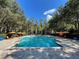 Beautiful community swimming pool surrounded by palm trees, lounge chairs, and umbrellas at 1020 Siena Park W Blvd # 304, Kissimmee, FL 34747