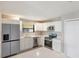 Modern kitchen featuring white cabinets, stainless steel appliances, and an island countertop with lots of lighting at 1022 Blue Horizon Dr, Deltona, FL 32725