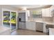 Modern kitchen with stainless appliances, white cabinets and sliding door to patio at 1022 Blue Horizon Dr, Deltona, FL 32725