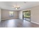 Bright living room with wood-look floors, fan, sliding glass doors and window with neutral paint at 1022 Blue Horizon Dr, Deltona, FL 32725