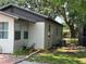 Exterior view of the home displaying air conditioning unit, hose, and landscaped backyard at 1101 28Th Nw St, Winter Haven, FL 33881