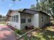 Exterior view of the home displaying a decorative brick trim, updated windows, and side yard at 1101 28Th Nw St, Winter Haven, FL 33881