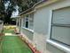 Side exterior view of the home, showcasing an easy access back entrance and well-maintained green turf at 1101 28Th Nw St, Winter Haven, FL 33881