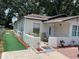 Exterior view of the home with a manicured lawn area and a cozy outdoor seating space by the front door at 1101 28Th Nw St, Winter Haven, FL 33881