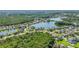 Community aerial view featuring homes near a lake surrounded by vibrant greenery and landscaping at 12134 Shadowbrook Ln, Orlando, FL 32828