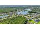 Wide aerial view showcasing community homes nestled around a picturesque lake surrounded by green landscape at 12134 Shadowbrook Ln, Orlando, FL 32828