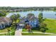 Expansive two-story lakefront home featuring a porte-cochere, mature landscaping, and pristine lawn at 12134 Shadowbrook Ln, Orlando, FL 32828