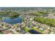 Sprawling aerial view featuring homes near a lake, complemented by lush green trees and manicured lawns at 12134 Shadowbrook Ln, Orlando, FL 32828