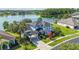 Beautiful lakefront property featuring a two-story home with porte-cochere, lush landscaping, and mature trees at 12134 Shadowbrook Ln, Orlando, FL 32828