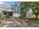 Backyard area with screen enclosure, mature trees and seating at 12134 Shadowbrook Ln, Orlando, FL 32828