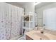 Bathroom with decorative floral shower curtain and a shelf with flowers at 12134 Shadowbrook Ln, Orlando, FL 32828