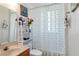 Cozy bathroom with patterned shower curtain, marble vanity, and decorative shelving for storage at 12134 Shadowbrook Ln, Orlando, FL 32828
