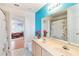 Bathroom with a dual sink vanity, large mirror and a blue accent wall at 12134 Shadowbrook Ln, Orlando, FL 32828