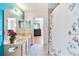 Bathroom with dual sinks, decorative mirrors and a shower with floral curtain at 12134 Shadowbrook Ln, Orlando, FL 32828