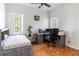 Bright bedroom features a bed, desk with computers, and a ceiling fan for a comfortable workspace at 12134 Shadowbrook Ln, Orlando, FL 32828