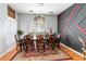 Formal dining room featuring a hardwood floor, ornate table set, modern chandelier, and decorative accent wall at 12134 Shadowbrook Ln, Orlando, FL 32828