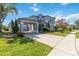 Elegant two-story home featuring a porte-cochere, lush landscaping, and classic architectural details at 12134 Shadowbrook Ln, Orlando, FL 32828